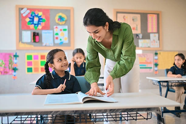 Preschool teacher assisting a student in classroom training session.