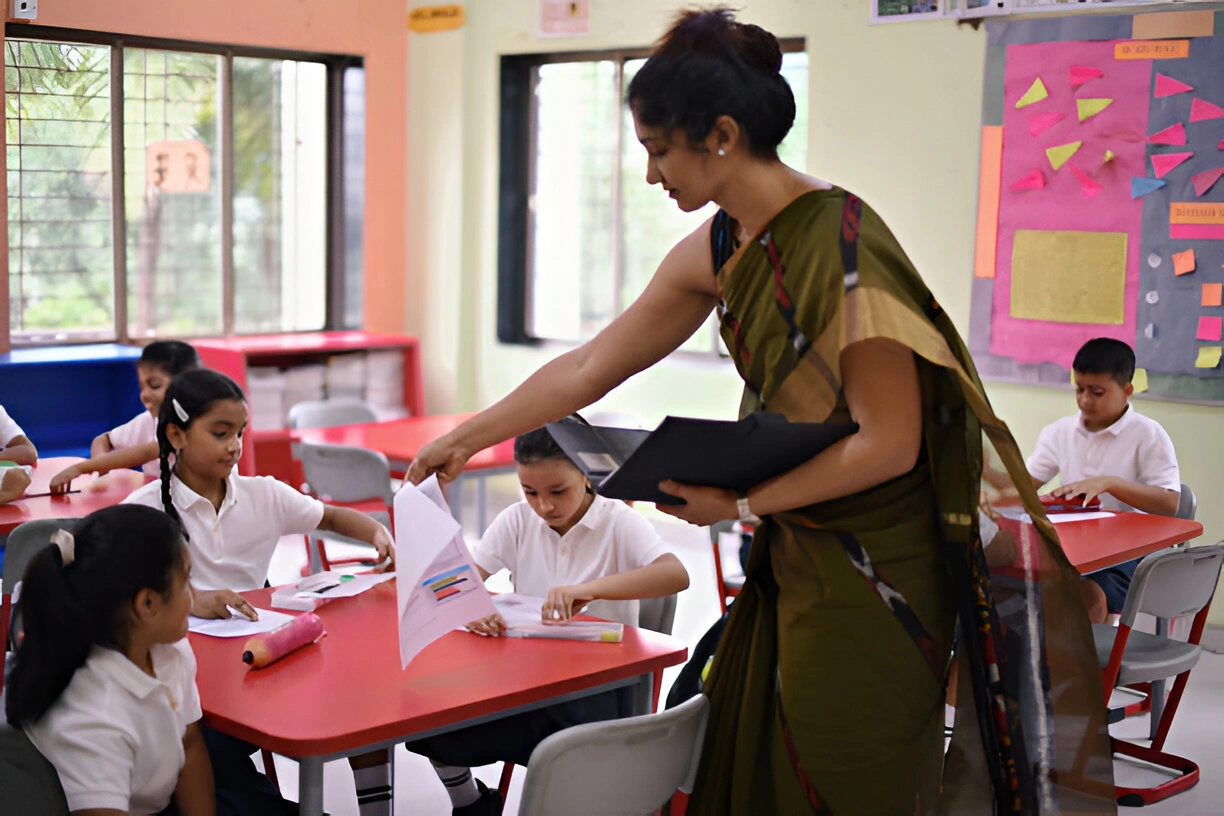 Teacher supporting students in classroom, relevant to diploma in special education online and remedial education course.