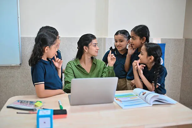 Teacher interacting with young students during phonics training for teachers.