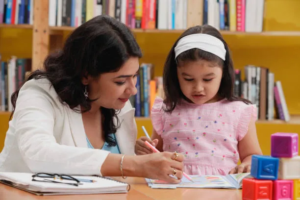 Teacher guiding a child during an early childhood teacher course activity in a classroom learning environment.