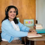 Student attending an online counselling course with laptop and headphones