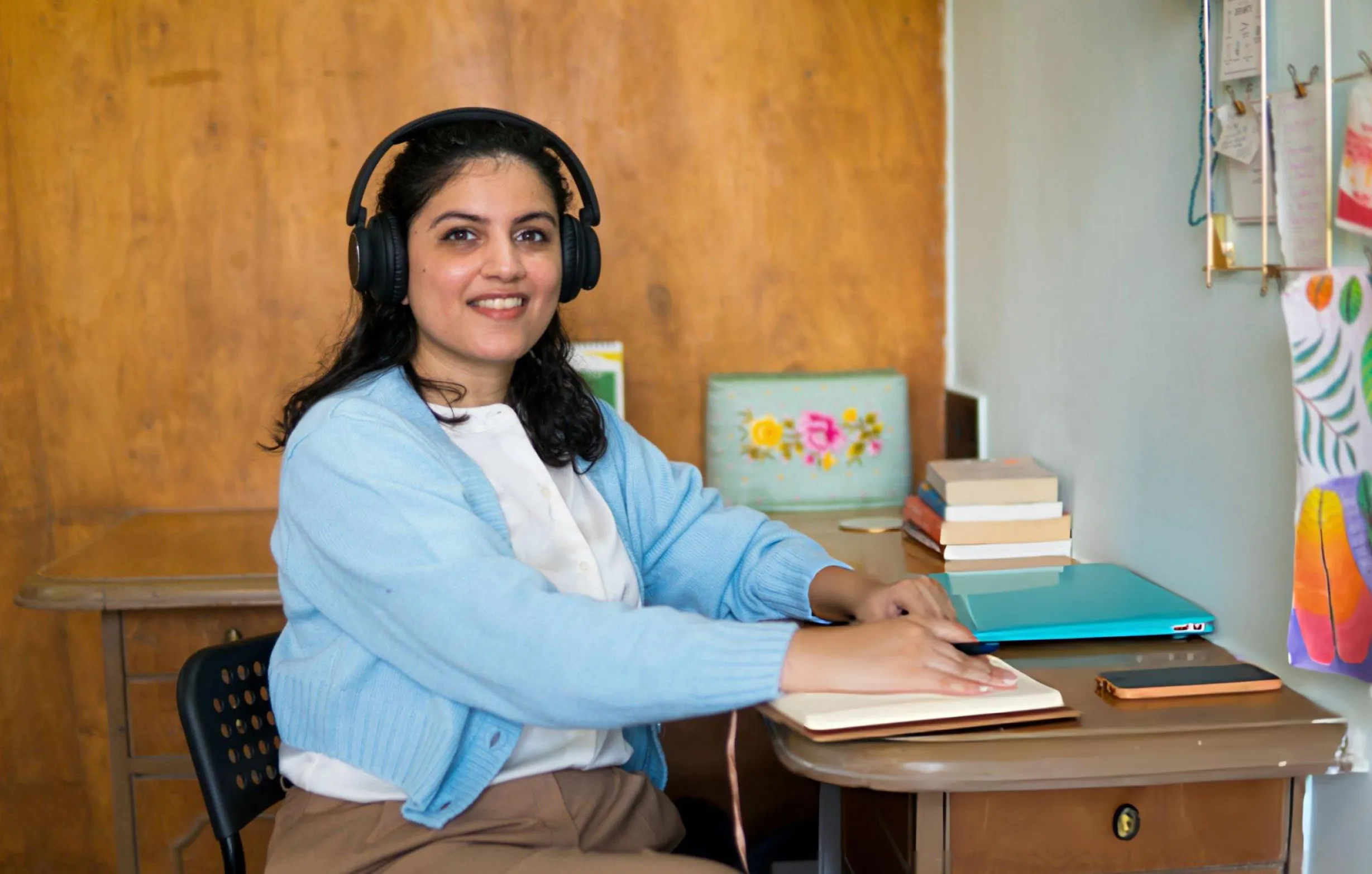 Student attending an online counselling course with laptop and headphones